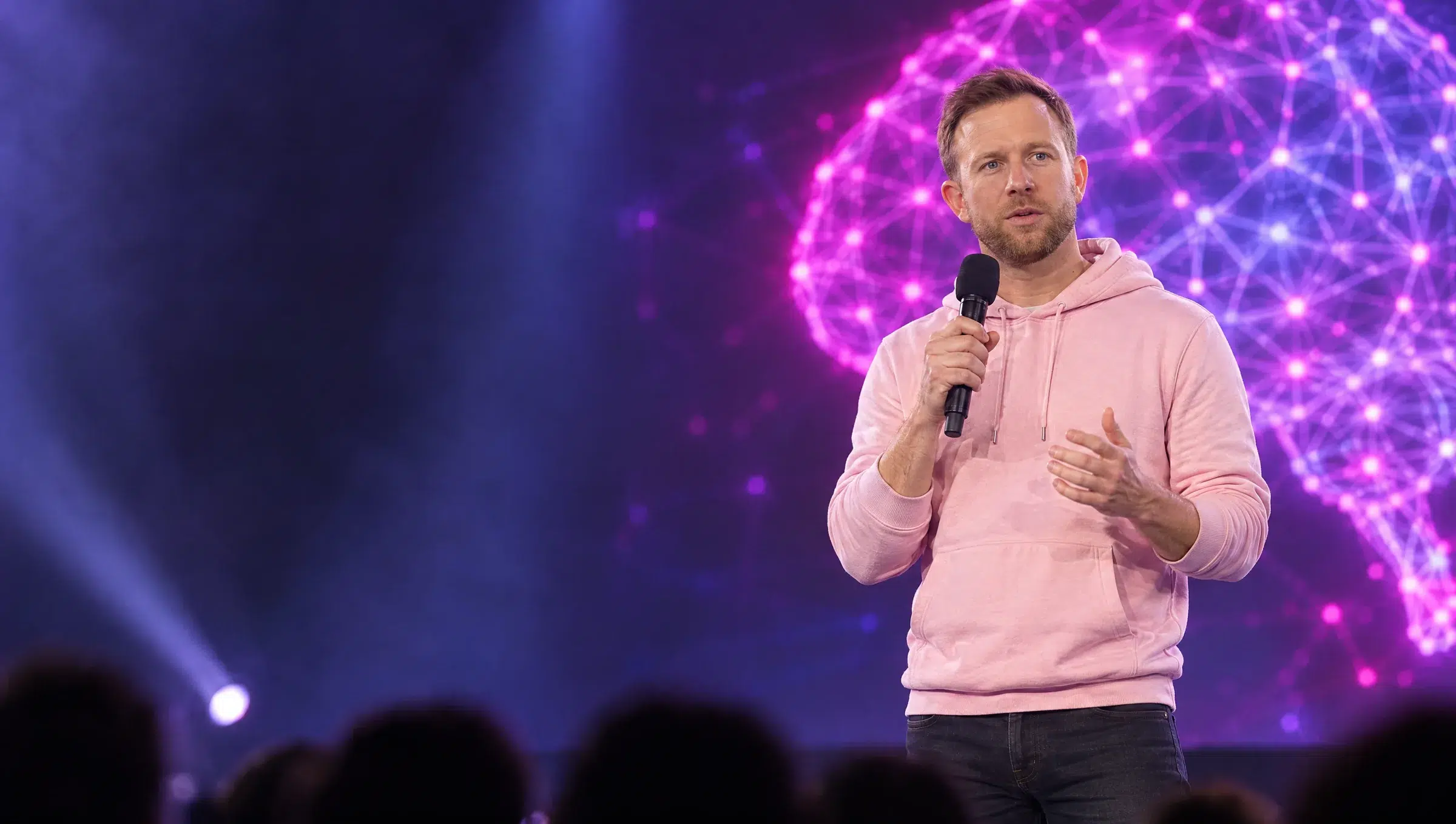 Florian Hübner im Herr-Tech-Hoodie spricht auf einer großen KI-Bühne